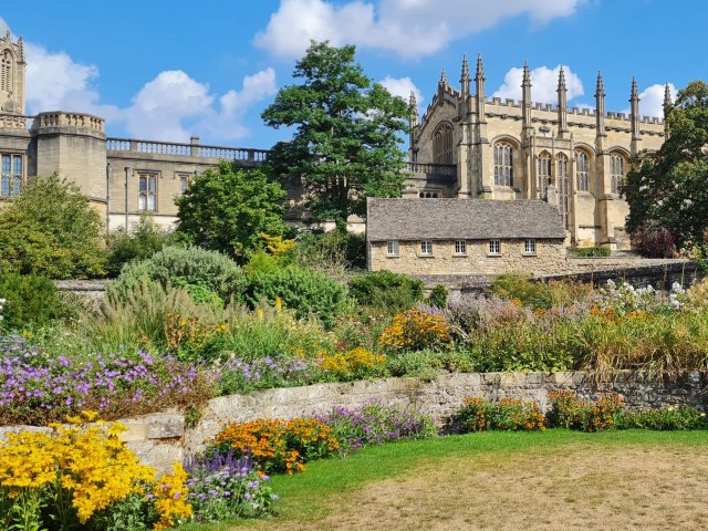 Colorful flowers and historic building at Oxford Botanic Garden in England