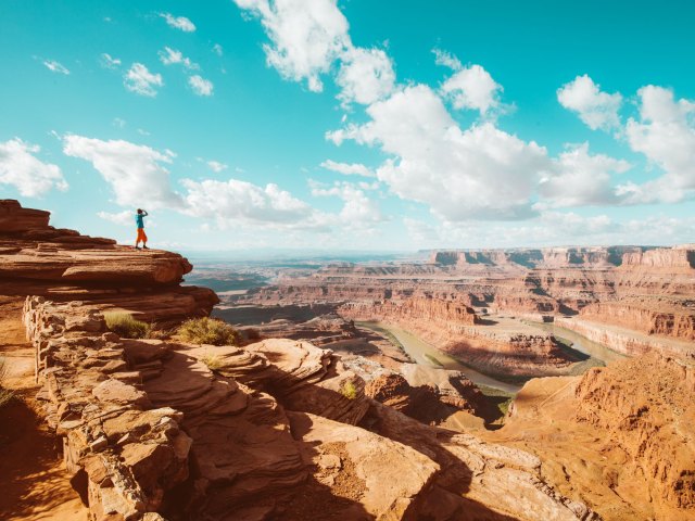 Person standing on ledge overlooking Canyonlands National Park in Utah