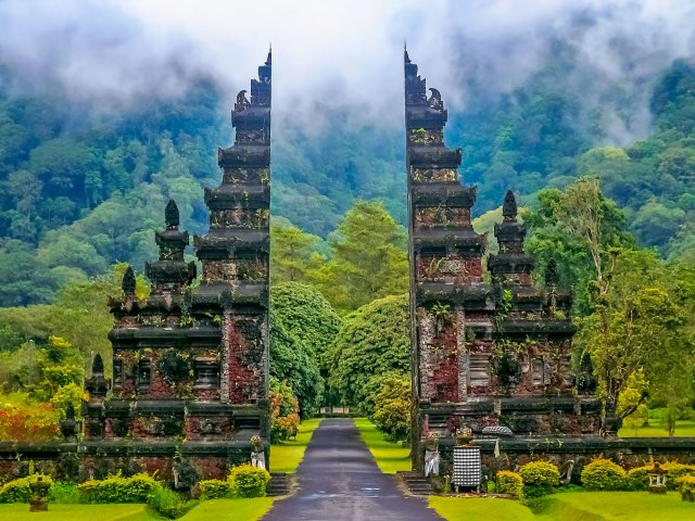 Temple gate surrounded by forested mountains in Indonesia