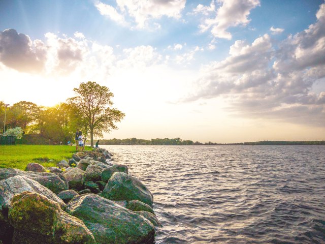 People standing on shores of a Minnesota lake at sunset