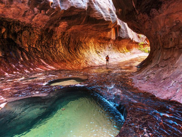 Hiker in tubular cave in Zion National Park