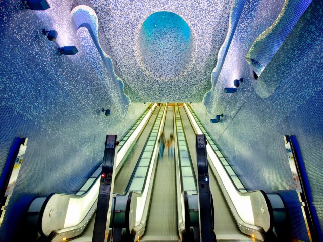 Escalators and blue-painted interior of Toledo Metro Station in Naples, Italy