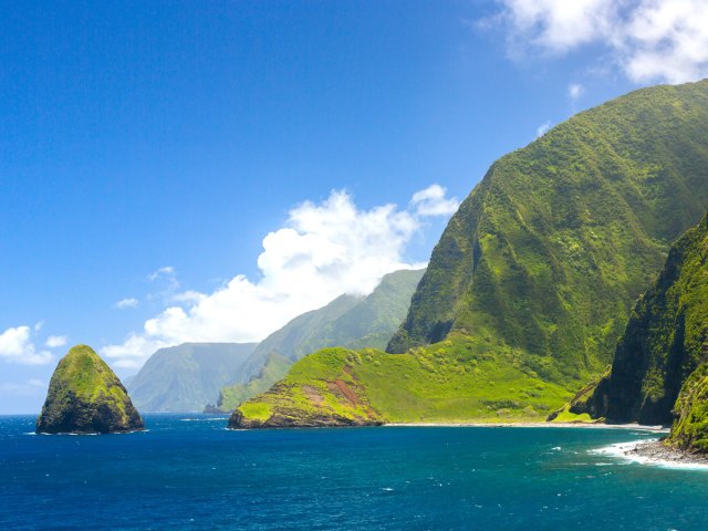 Lush green Kalaupapa Cliffs in Hawaii, seen from the sea