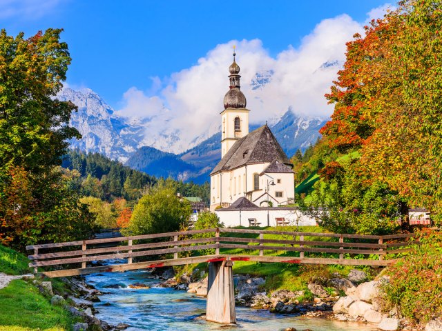 Church, bridge over river, and fall foliage in Bavaria, Germany