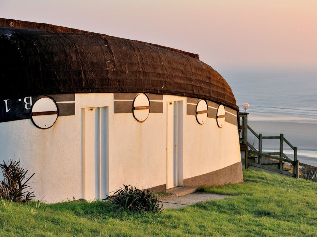 Upturned boat house in Équihen-Plage, France, with view of coastline
