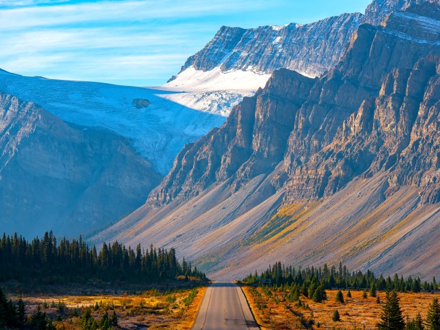 Empty Trans-Canada Highway leading to tall mountain peaks