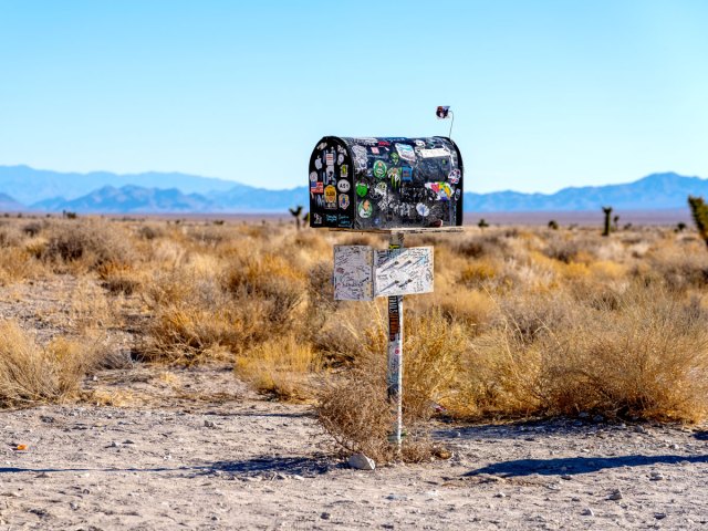 Image of the sticker-covered Black Mailbox in the Nevada Desert