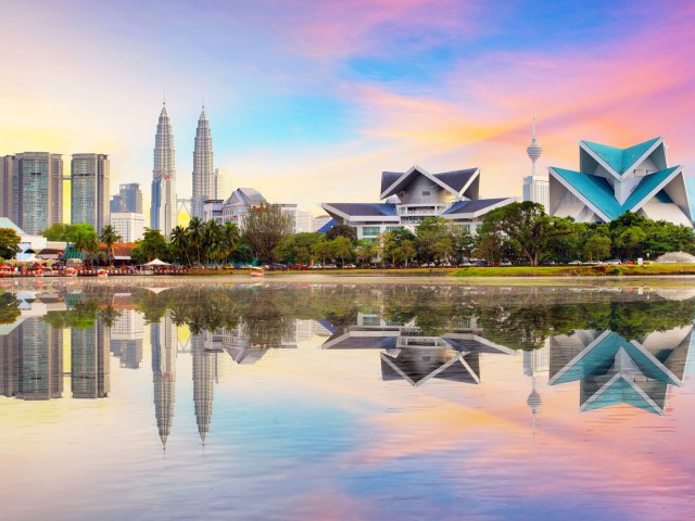 Buildings in Kuala Lumpur, Malaysia, with reflection on lake at sunset