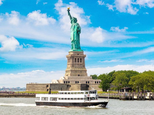 Boat cruising past Statue of Liberty in New York Harbor