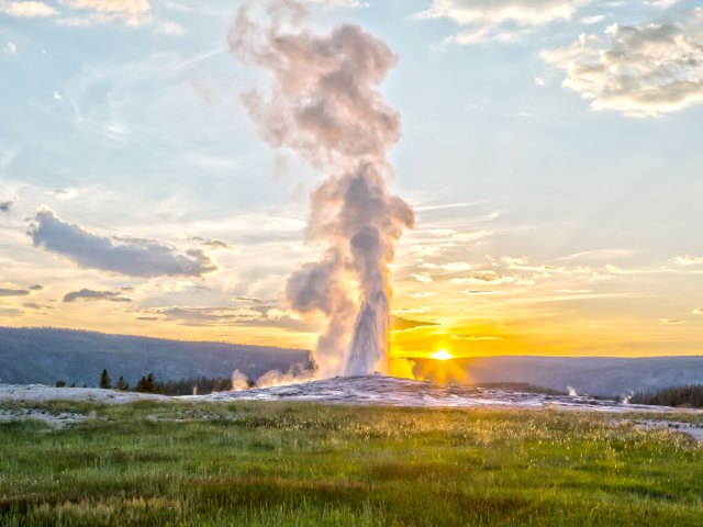 Old Faithful Geyser erupting at sunrise in Yellowstone National Park
