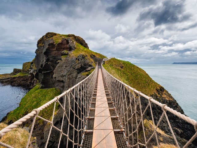 Pedestrian suspension bridge on rocky coastline of Great Britain