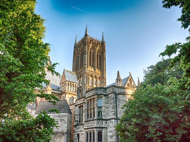 View of Lincoln Cathedral in England between trees