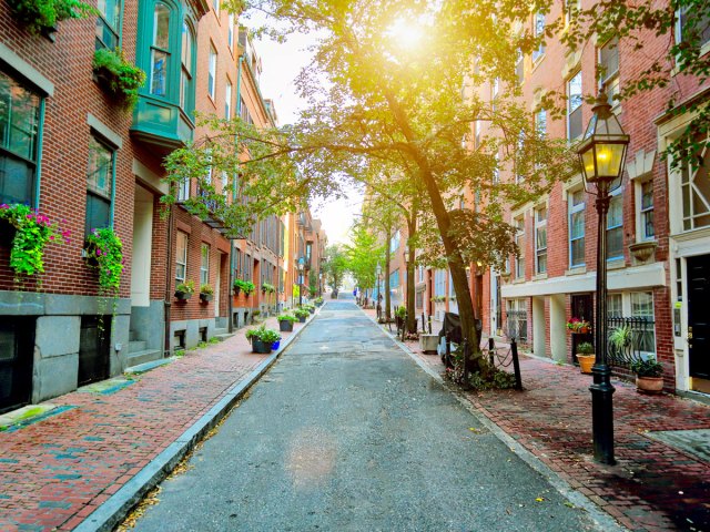 Narrow street lined with brick row homes in Boston, Massachusetts