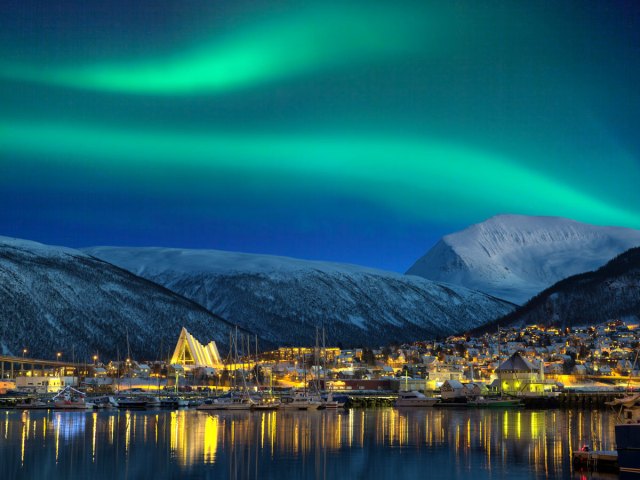 Northern lights seen over waterfront cityscape of Tromsø, Norway