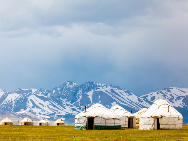 Yurts in the shadow of mountain range in Kyrgyzstan