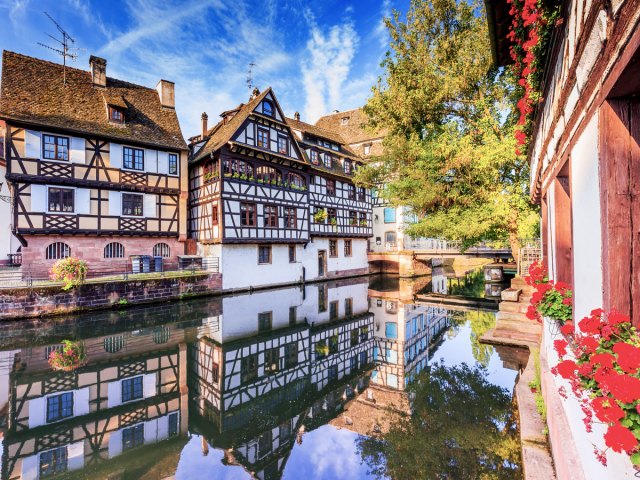 Traditional buildings reflecting on canal in Strasbourg, France 