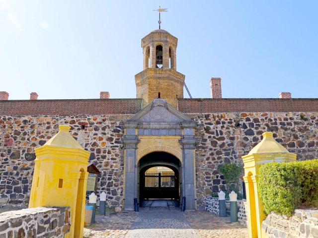 Entrance to Castle of Good Hope in South Africa flanked by bright yellow guard houses
