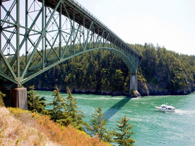 Boat passing under Deception Pass Bridge in Oak Harbour, Washington