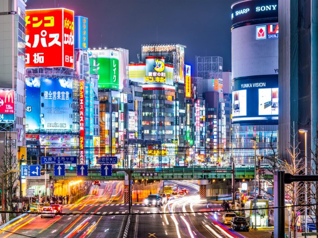 Time lapse of street lined with billboards and skyscrapers at night in Tokyo, Japan