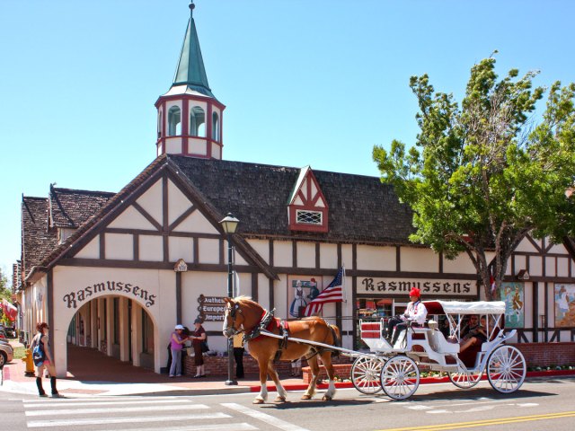 Horse-drawn carriage in front of Danish-style building in Solvang, California