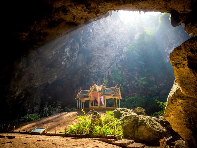 Temple in cave with light-filled opening in Thailand's Khao Sam Roi Yot National Park