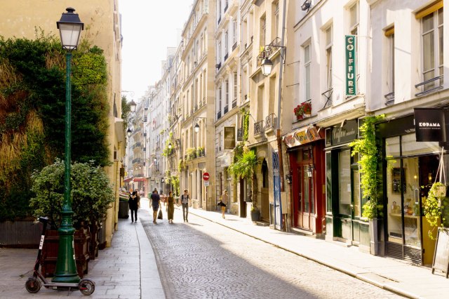 Pedestrians on narrow cobblestone street in Paris, France