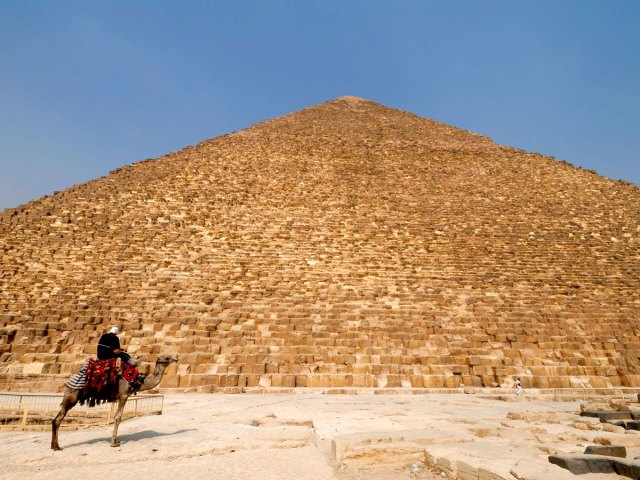 Person on camel in front of Great Pyramid of Giza, Egypt