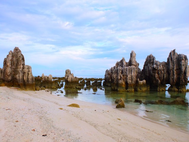 Rock formations along sandy beach in Nauru