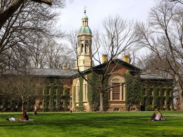 Students lounging on grass in front of Nassau Hall at Princeton University