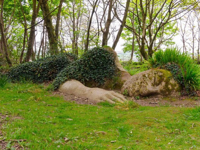 Garden sculpture of a giant person lying down in grass at Lost Gardens of Heligan, England