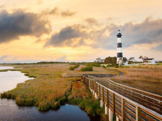 Wooden pathway leading to striped lighthouse on Roanoke Island, North Carolina