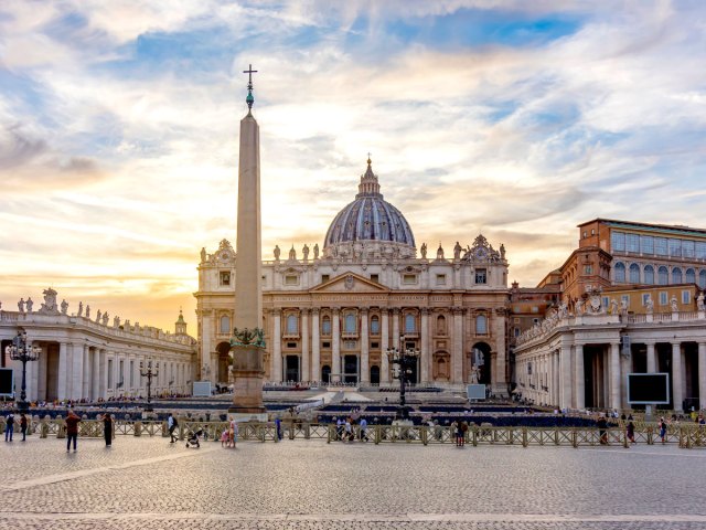 Crowds gathering in St. Peter's Square in Vatican City at sunset