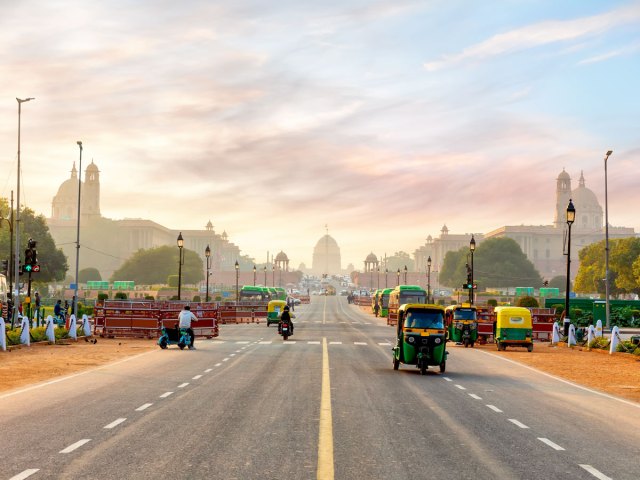 Looking down wide avenue on hazy day in Delhi, India