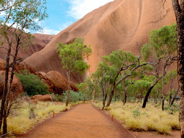 Dirt path leading to Uluru rock formation in Australia