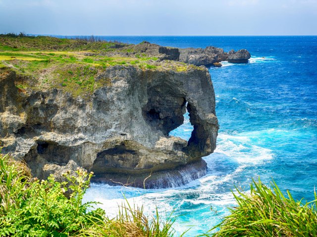 Natural arch and cliffs along coast of Okinawa, Japan
