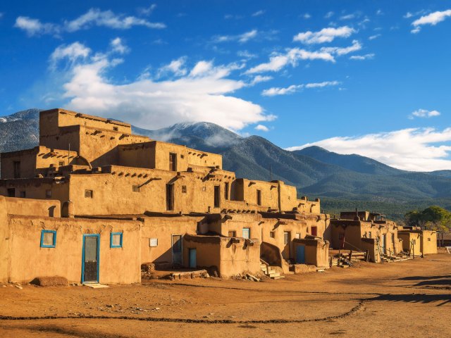 Adobe dwellings of Taos Pueblo, New Mexico, with mountains in background
