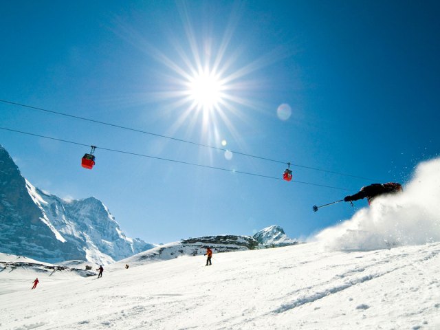 Ski lift and skiers on snow-covered mountain in Grindelwald, Switzerland 