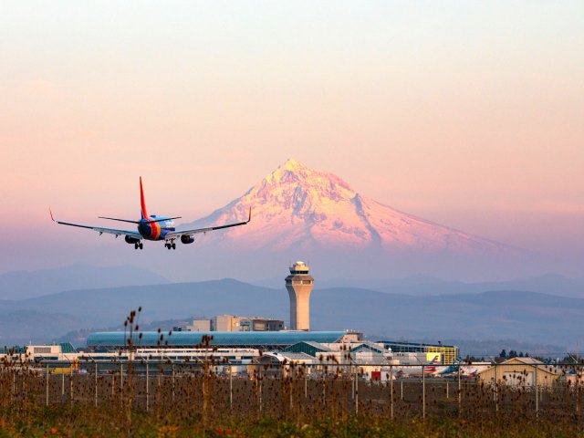 Southwest Airlines airplane landing with snow-capped peak in background