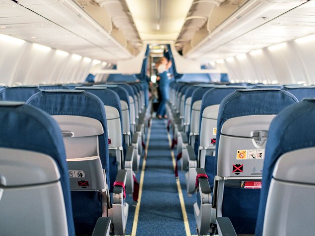 View of airplane cabin from aisle looking toward front of plane