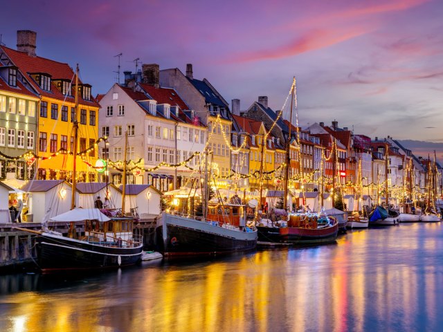 Boats along waterfront at night in Copenhagen, Denmark