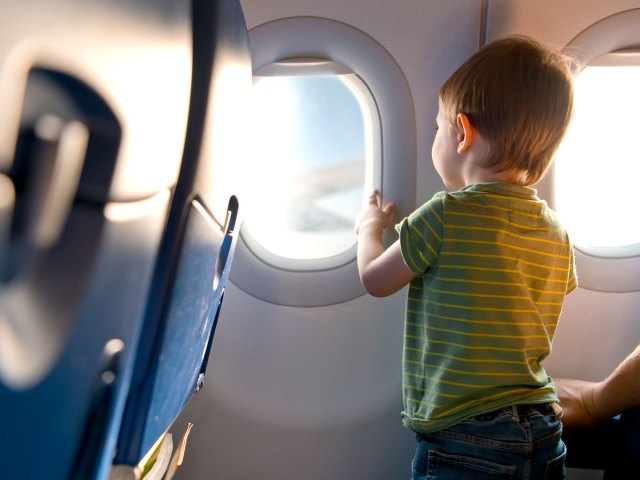 Toddler looking out of airplane window
