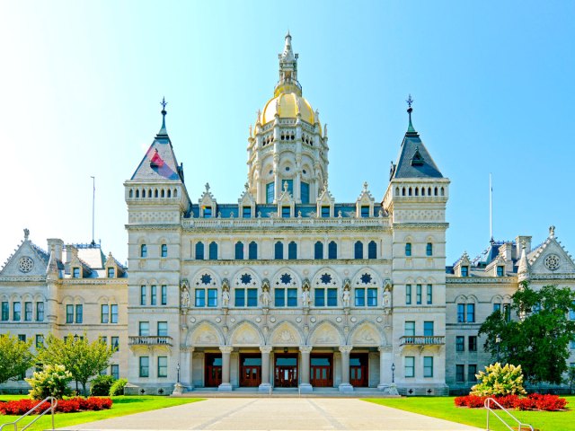 Grandiose exterior of the Connecticut State Capitol topped by gold-domed tower 