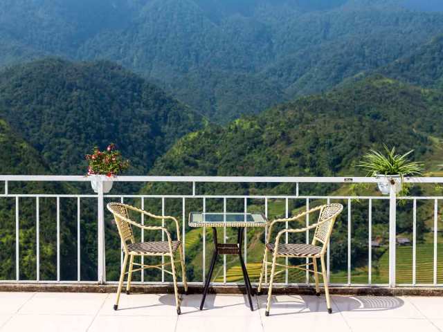 Table and chairs on patio overlooking lush valley in Vietnam
