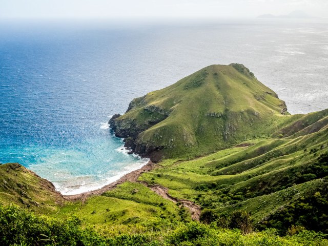 View of lush peninsula and Caribbean sea on island of Saba, seen from above