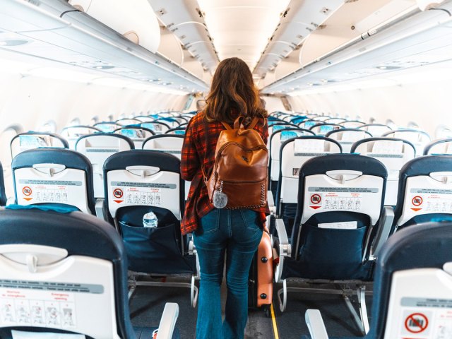 Passenger walking through airplane aisle