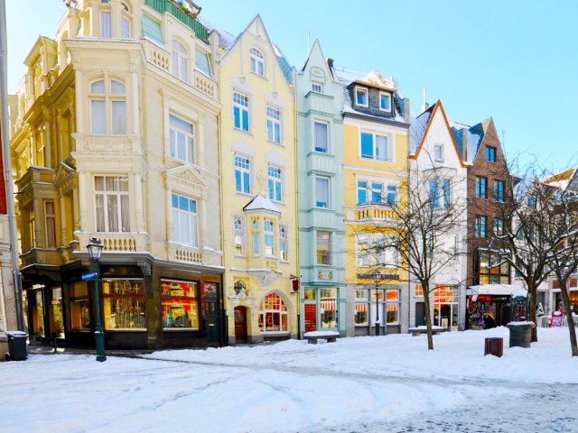 Snow-covered street and colorful row homes in Aachen, Germany