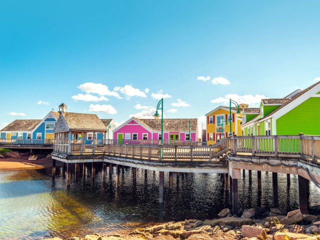 Brightly painted homes on pier, seen from shore, on Prince Edward Island