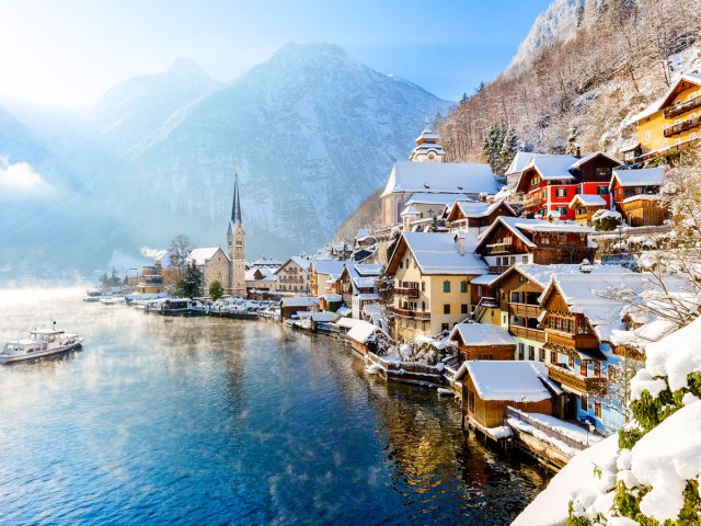 Snow-covered buildings beside lake and mountains in Hallstatt, Austria
