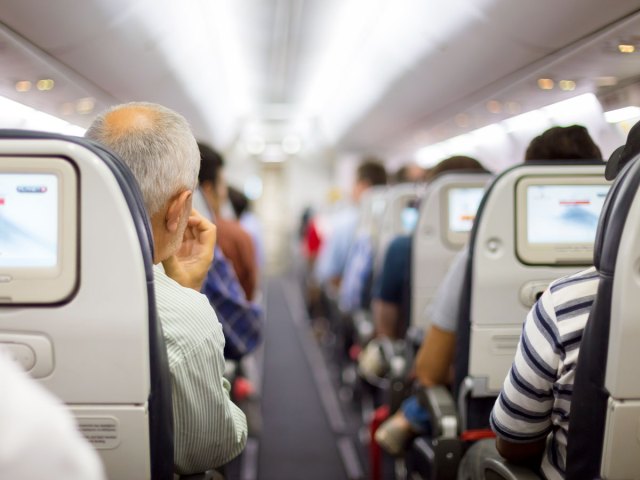 Passengers on airplane seen from behind