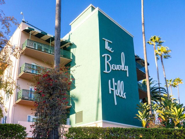 Palm trees and sign on facade of Beverly Hills Hotel in California